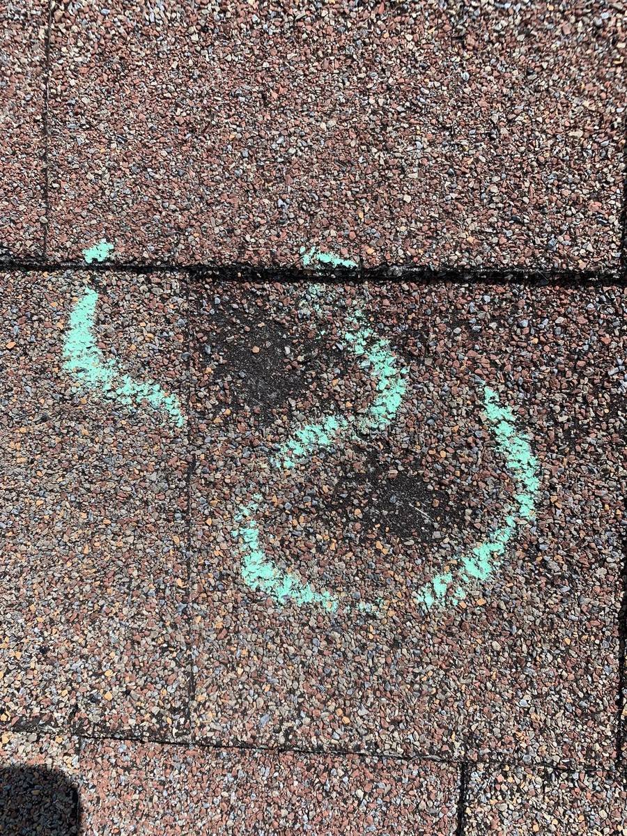 Close-up of hail damage impact on shingle during a roof inspection in St. Louis
