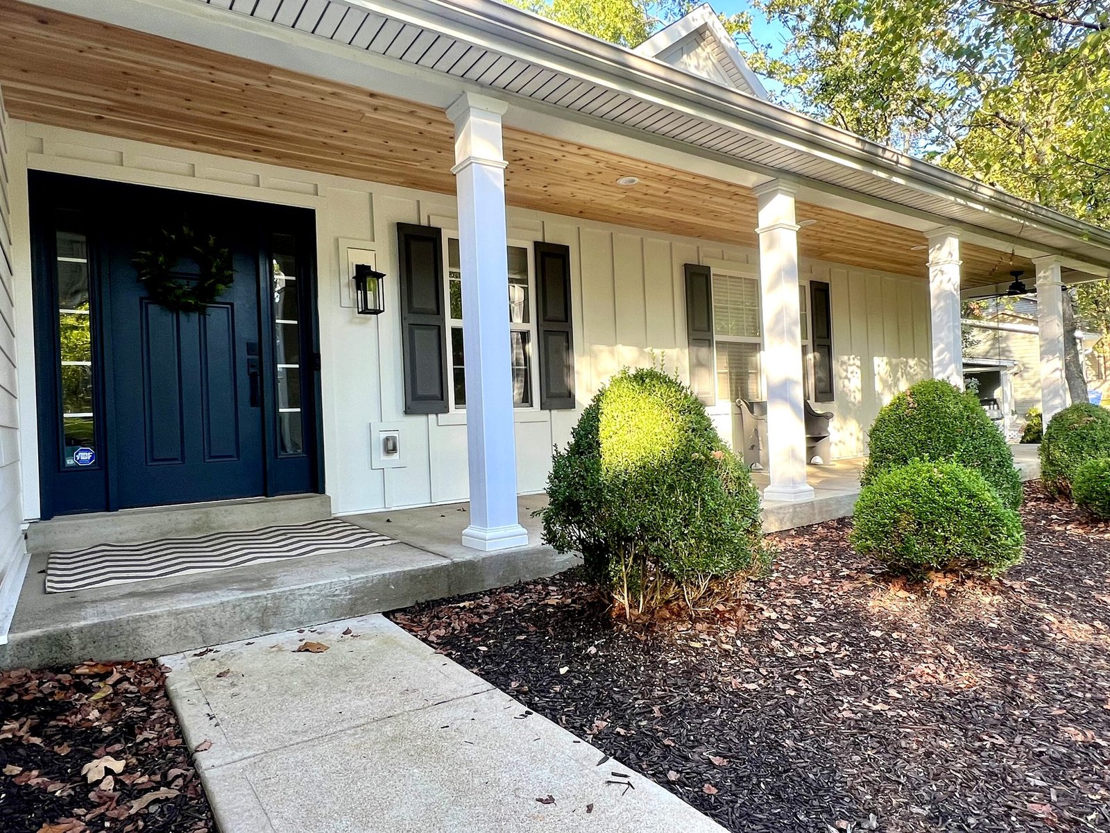 James Hardie board and batten siding with cedar porch ceiling and dark blue entry door in St. Louis