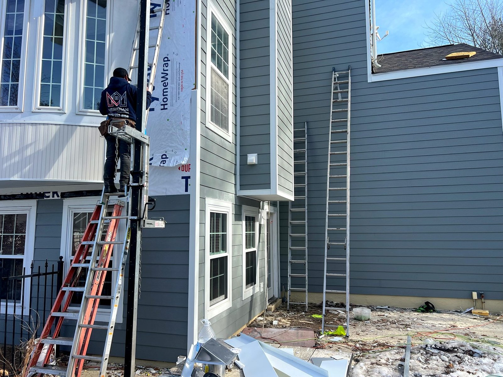 Meridian crew installing gray James Hardie lap siding in St. Louis MO