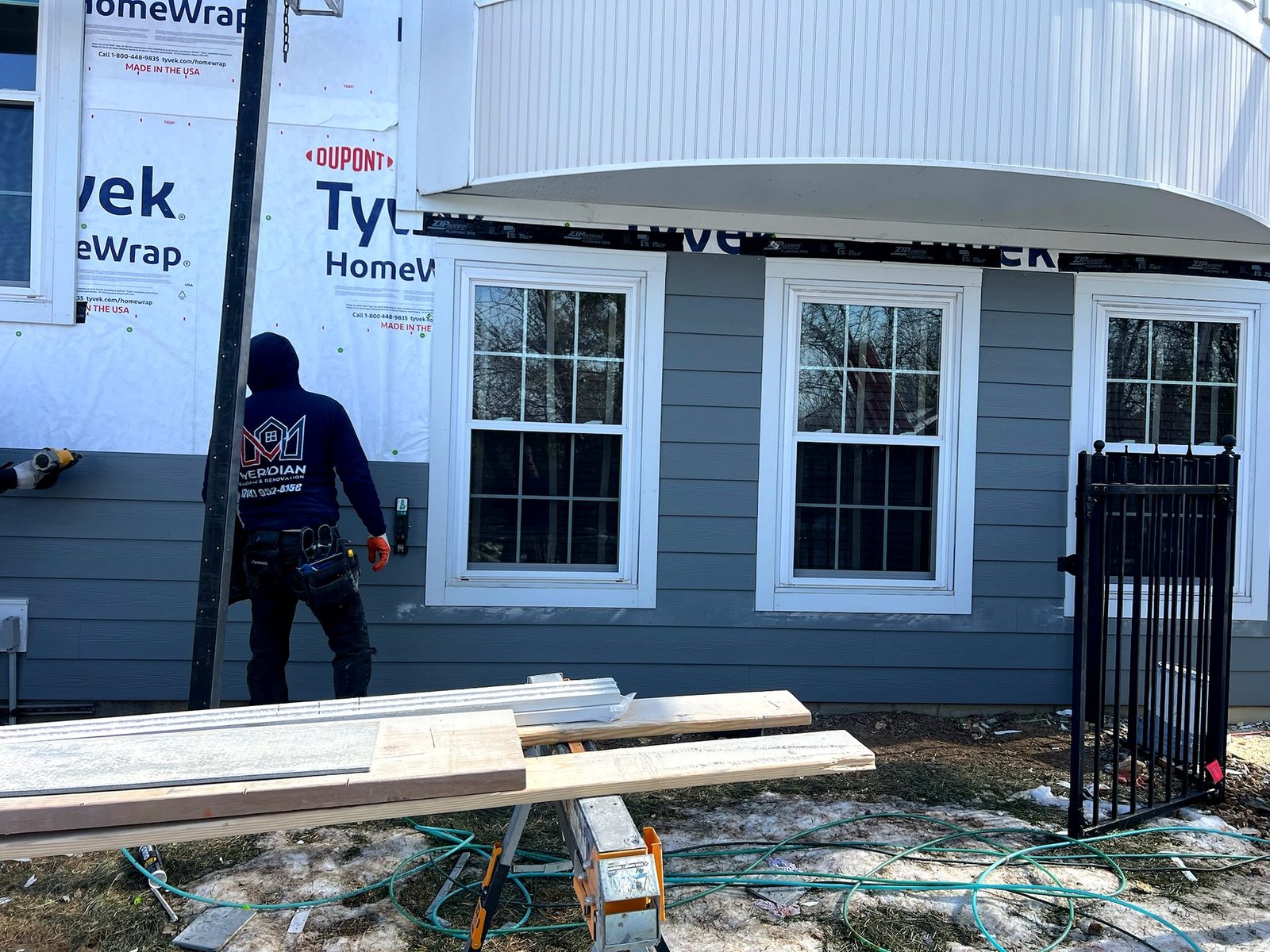 Gray James Hardie lap siding with windows installed by Meridian Roofing