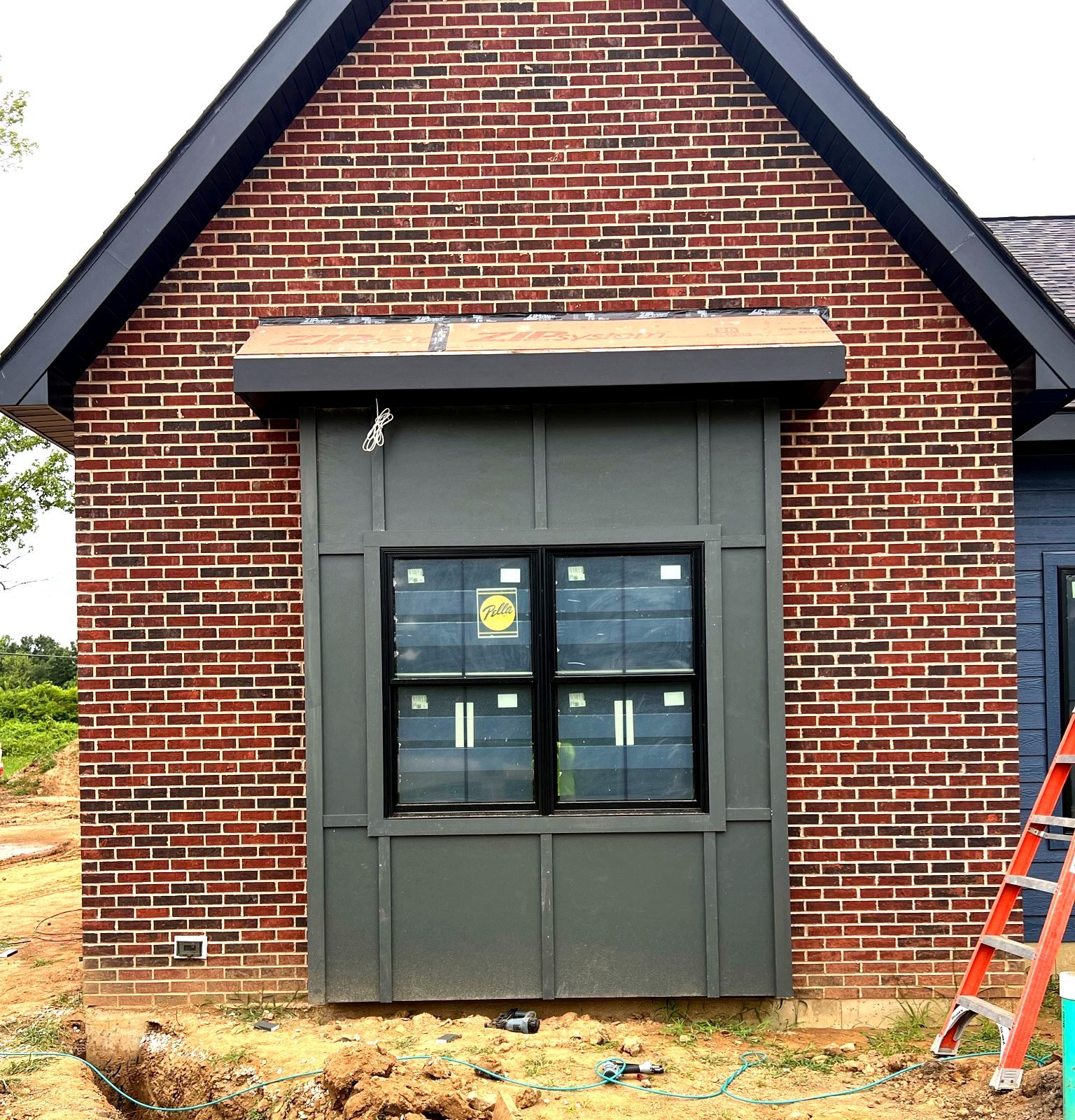 Hardie panel siding with brick accent installed by Meridian Roofing
