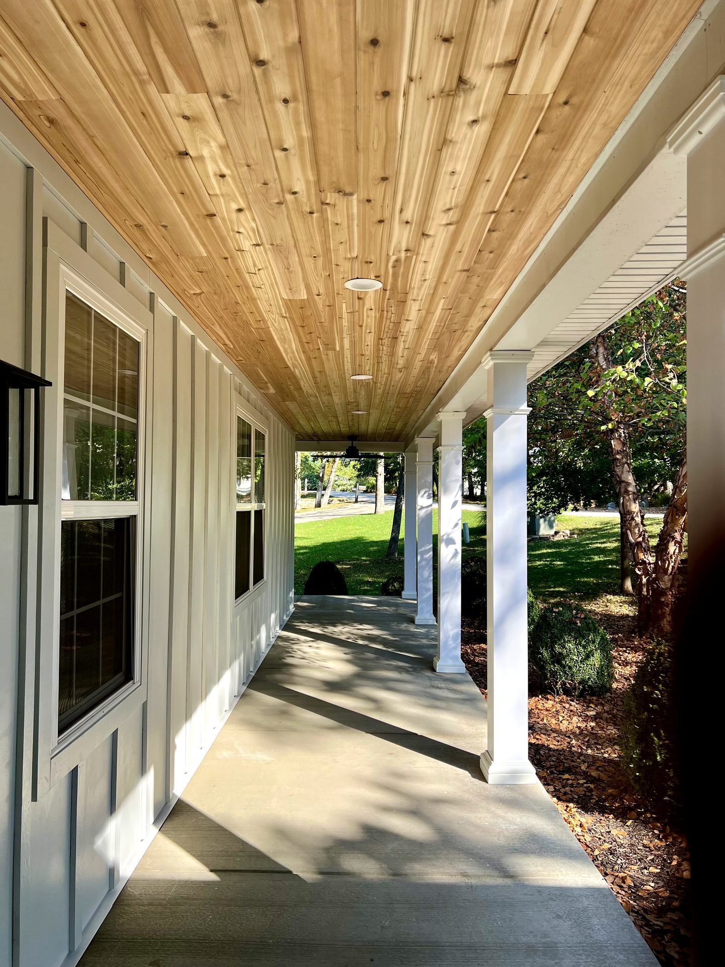White James Hardie board and batten siding with cedar tongue and groove porch ceiling detail