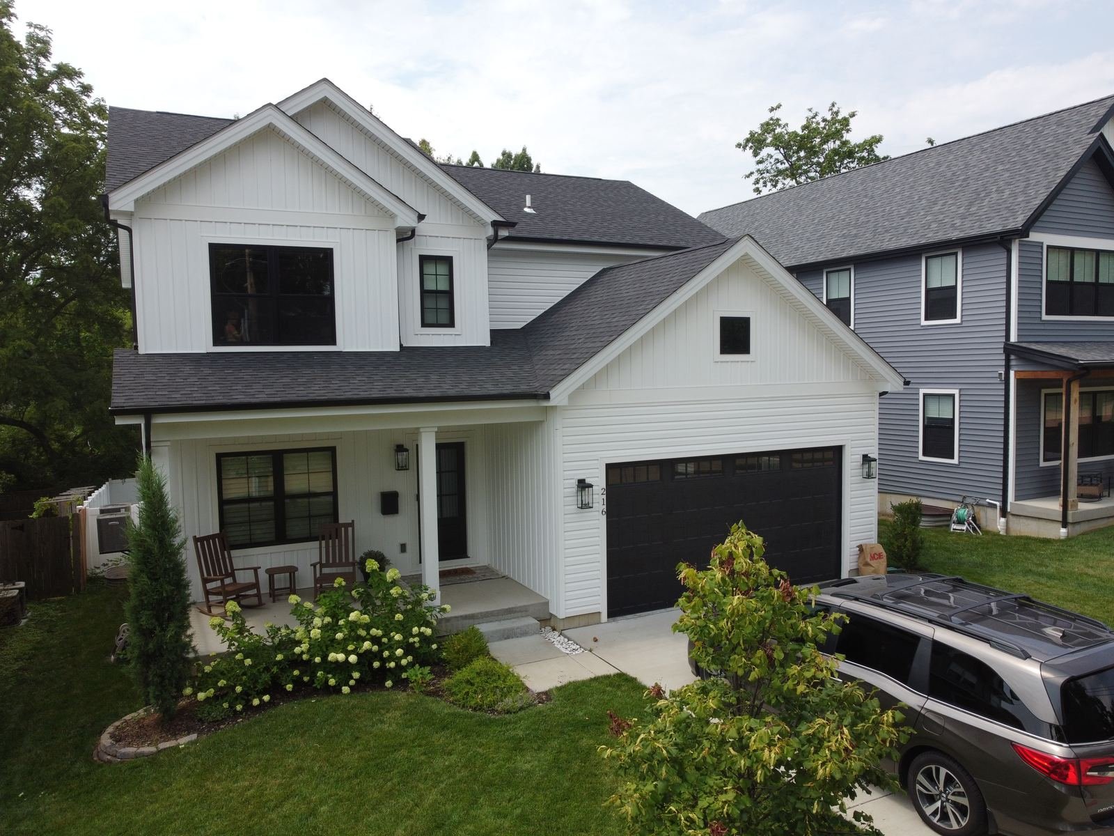 Aerial drone view of white vinyl siding installation on St. Louis modern farmhouse with board and batten gable accents