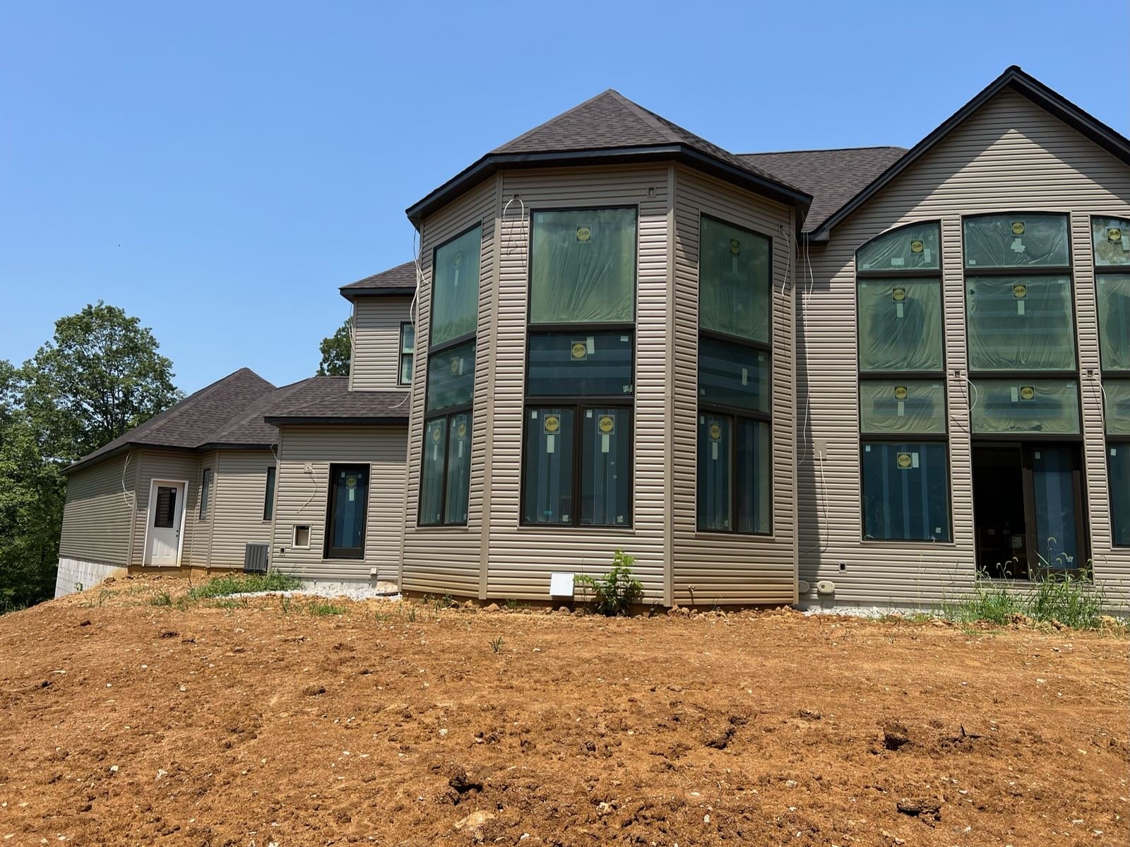 Tan vinyl lap siding installation on multi-gable home in St. Louis by Meridian Roofing