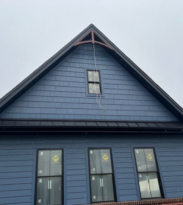 Meridian Roofing and Renovation team repairing damaged siding on a home in St. Louis, MO.