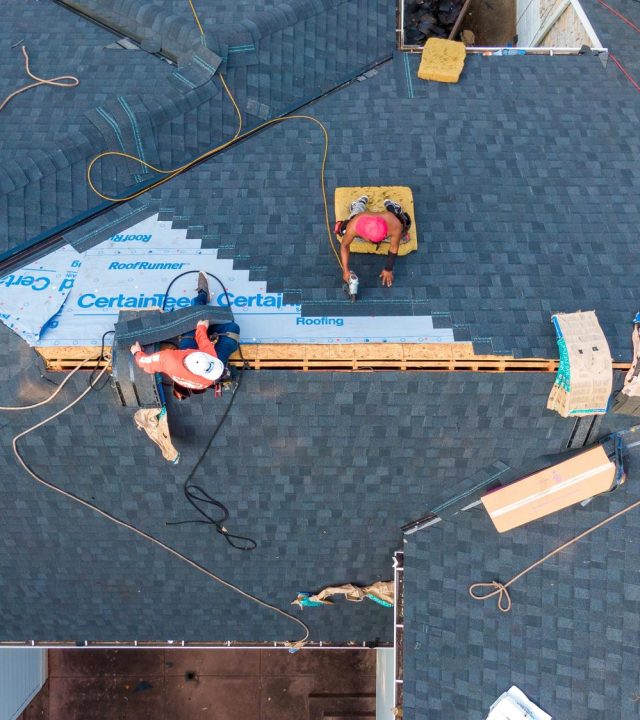 Roofing crew installing shingles by roof replacement in Ballwin, MO